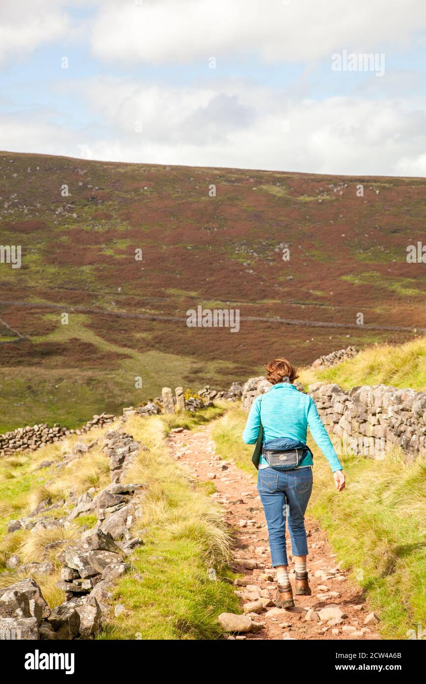 Femme marchant seule dans la campagne du parc national de Peak District Angleterre Royaume-Uni Banque D'Images