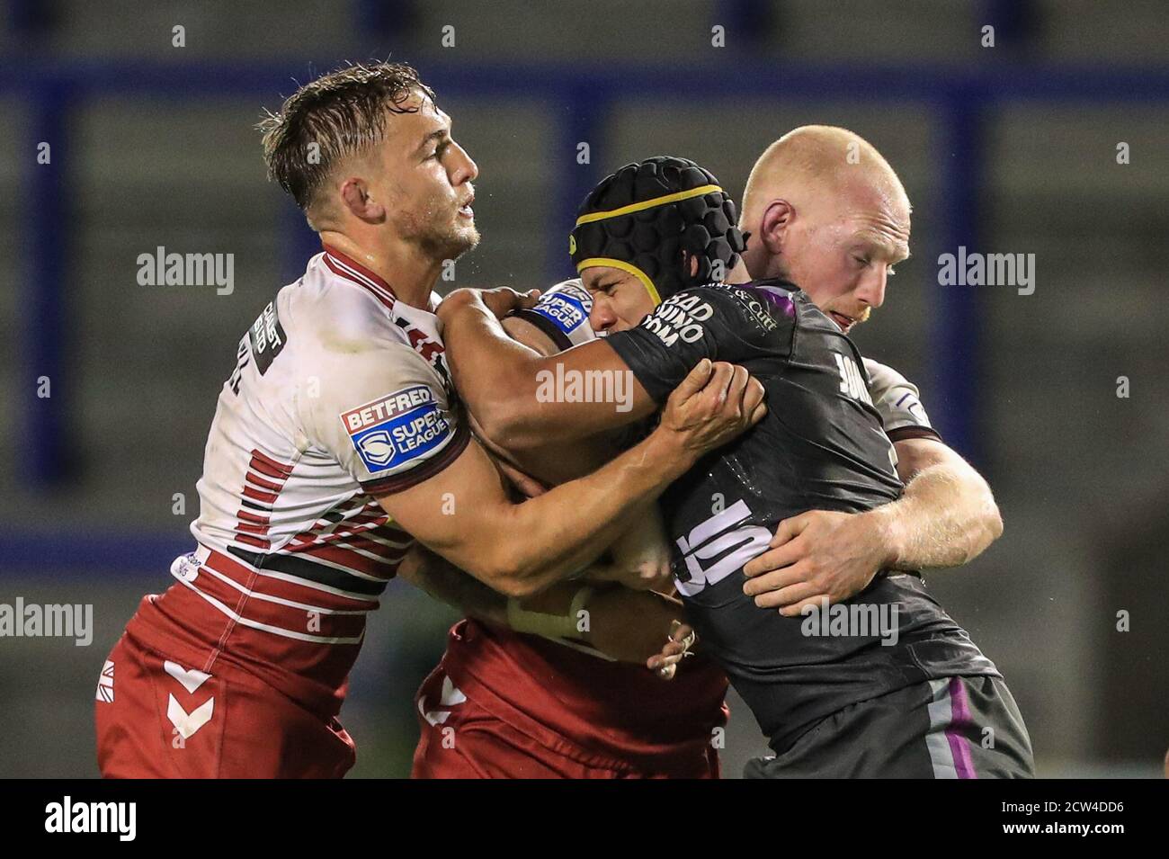 Ben Jones-Bishop (5) de la Trinité de Wakefield est abordé par Sam Powell (9) de Wigan Warriors et Liam Farrell (12) de Wigan Warriors Banque D'Images