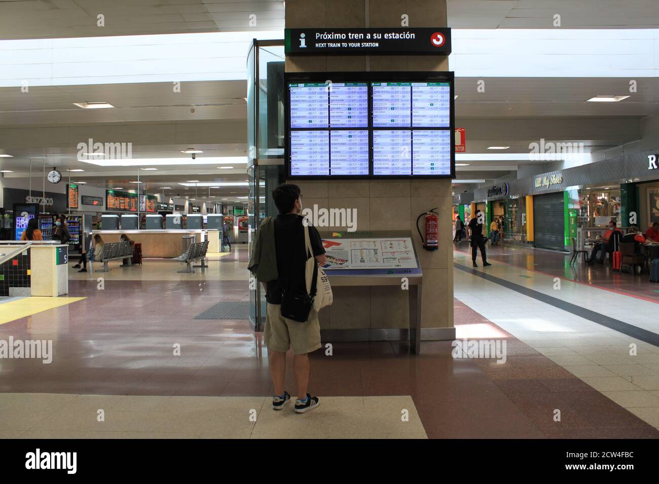 Un passager regarde l'écran avec des informations sur le départ des trains à la gare de Chamartin, à Madrid (Espagne) en septembre 2020. / ANA BORNAY Banque D'Images