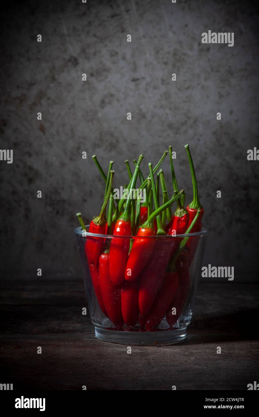 Still Life photo des poivrons rouges dans un vase en verre Grunge l'arrière-plan Banque D'Images