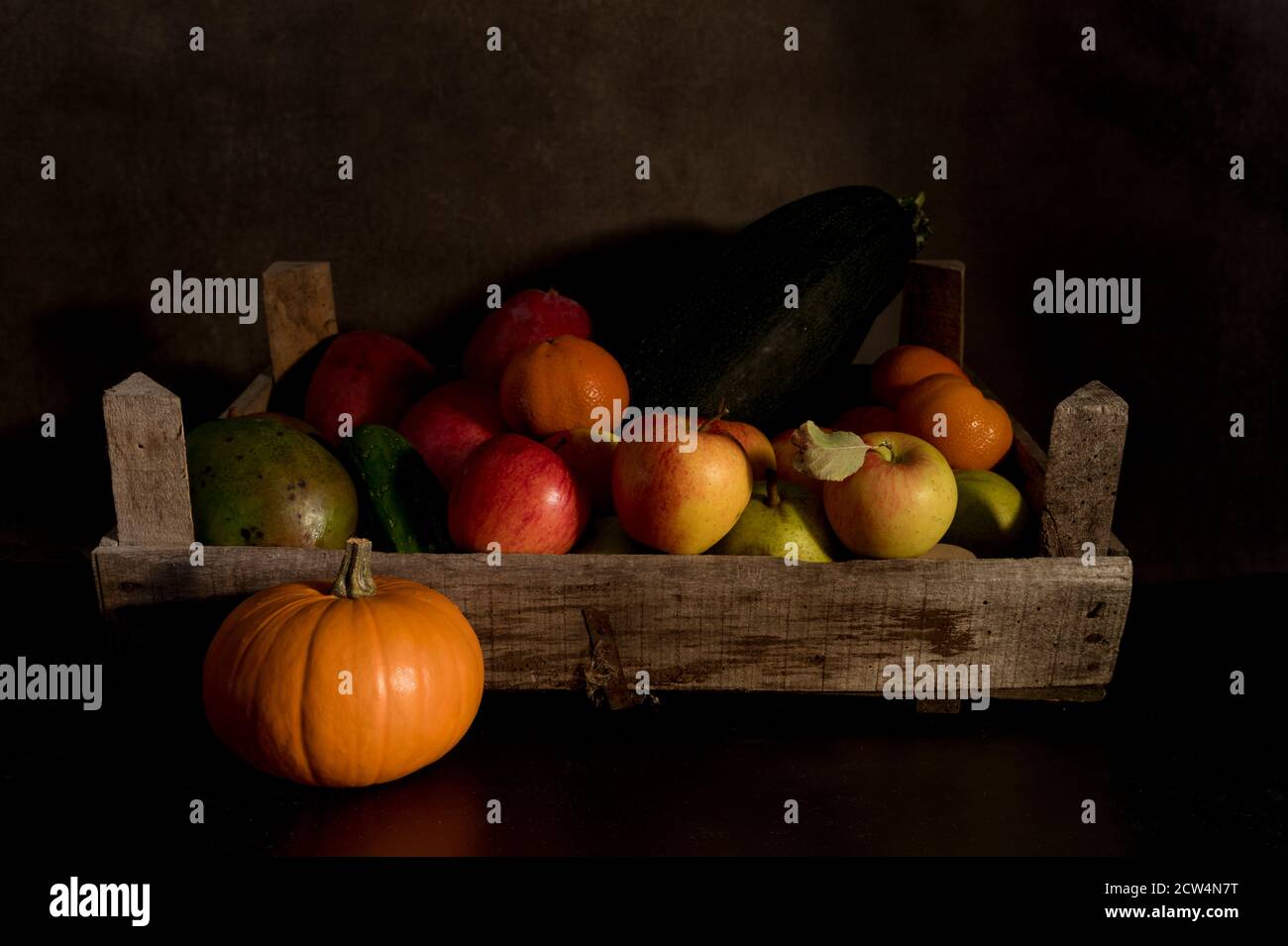 une vie de fruits dans une ancienne boîte en bois avec un fond marron et noir mixte Banque D'Images