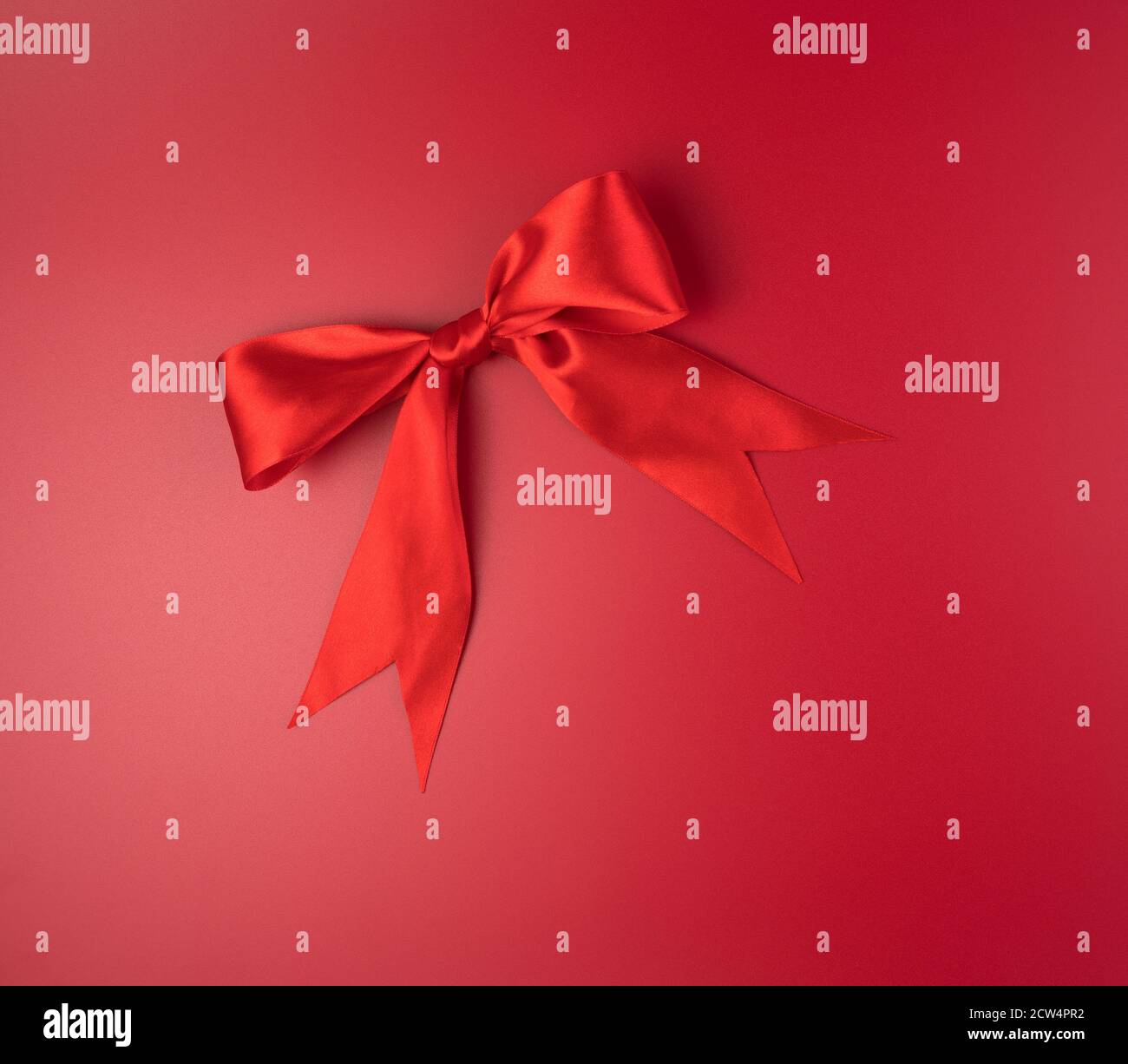 Grand noeud rouge sur fond rouge. Banque D'Images