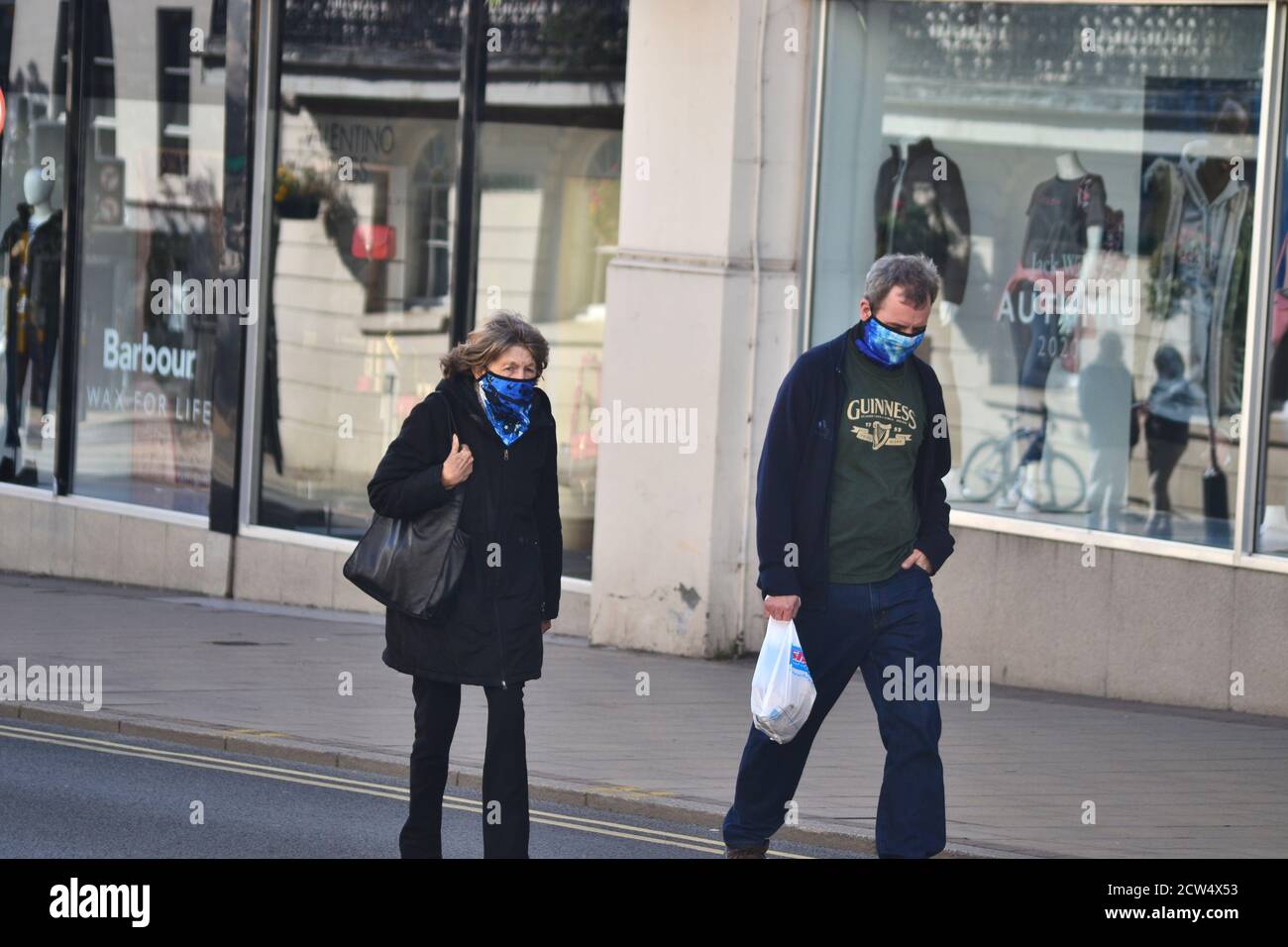 Une femme et un homme âgés marchent le long de la Parade, Leamington Spa, tout en portant des revêtements de visage assortis Banque D'Images