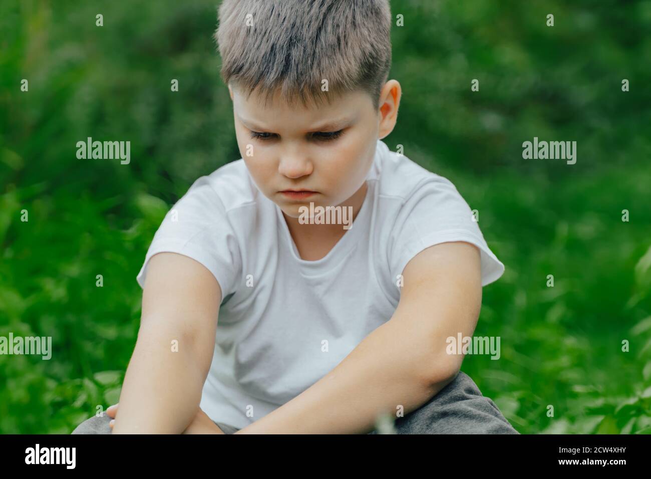 enfant malheureux couvrant son visage avec les mains. pleurs garçon assis  seul dans le parc. Dépression, stress, frustration, tristesse,  intimidation, abus, proble scolaire Photo Stock - Alamy