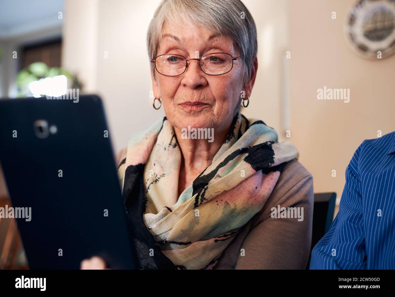 Couple senior à domicile passer un appel vidéo à la famille ou Regarder des films sur une tablette numérique Banque D'Images