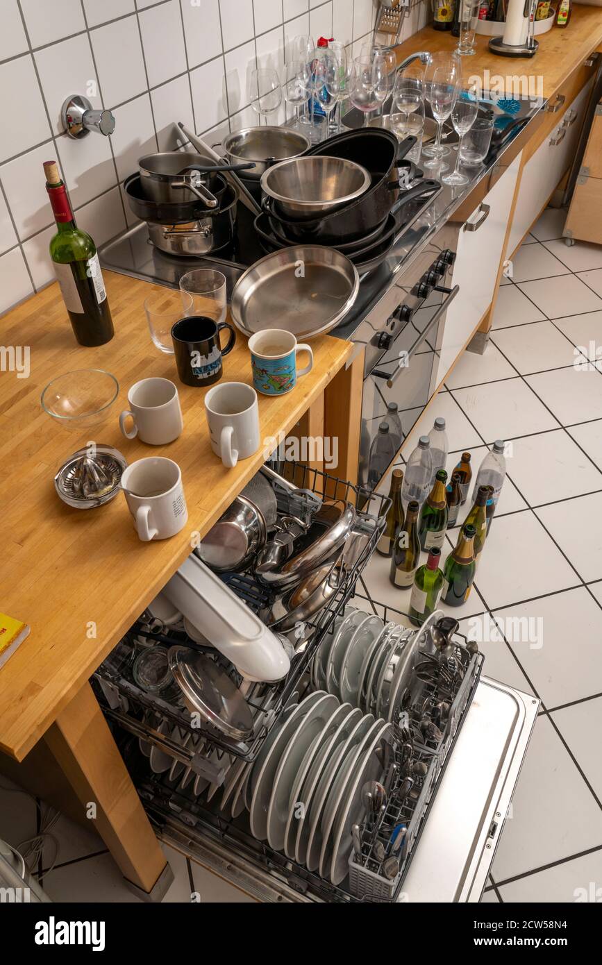 Cuisine après un dîner plus grand, partie de cuisine, lave-vaisselle, plein, avec vaisselle nettoyée, verres sales, casseroles, ustensiles de cuisine sur l'évier, en attente d'être Banque D'Images