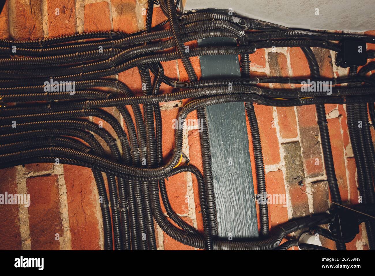 Mur en brique avec conduit électrique conduit en PVC. Banque D'Images