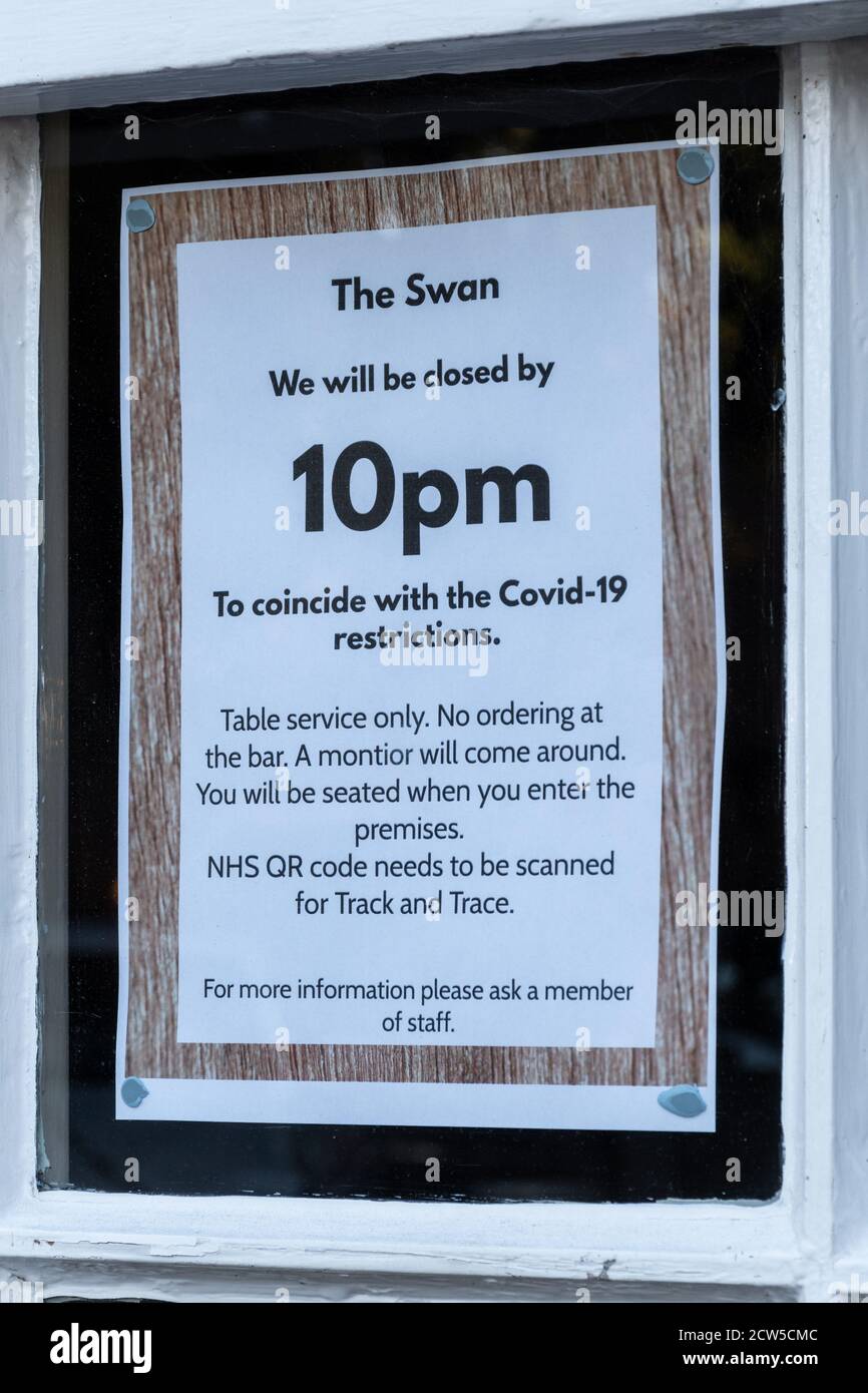 Avis dans la fenêtre du pub au sujet des restrictions du coronavirus britannique Covid-19 et de l'heure de fermeture anticipée du pub à 22:00, Royaume-Uni, septembre 2020 Banque D'Images