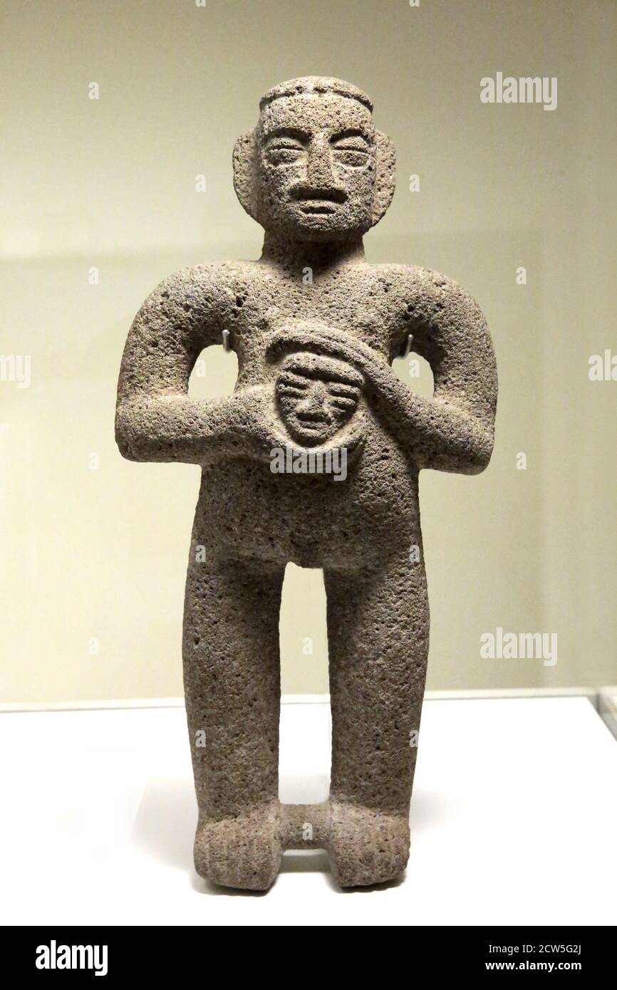 Figure mâle tenant une tête de trophée. Sculpture en pierre ( 1000-1500 AD). Art précolombien Costa Rica. Museumj des cultures du monde, Barcelone, Espagne. Banque D'Images