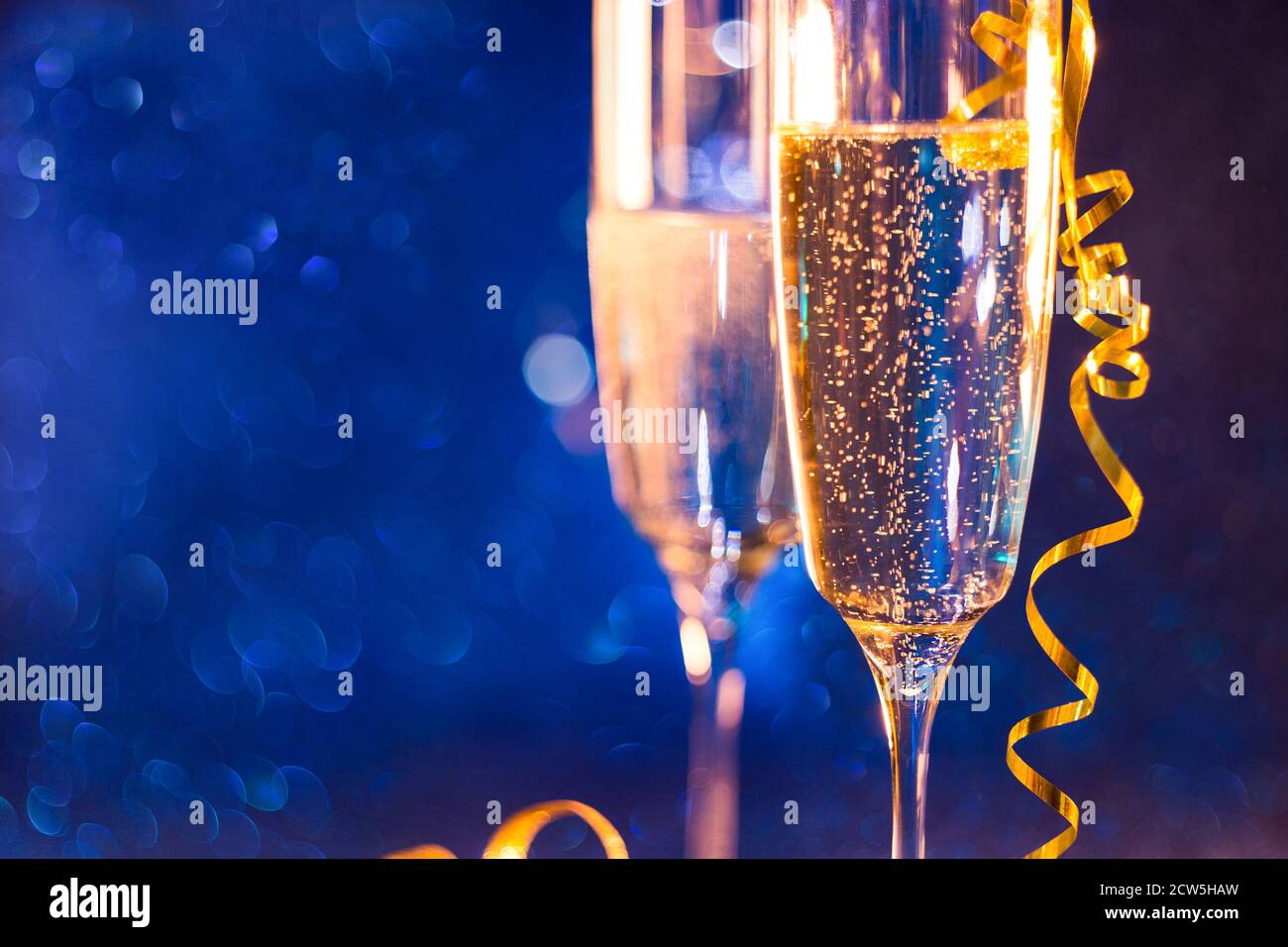 Arrière-plan de Noël et du nouvel an avec deux gobelets, verre de vin champagne et effet bokeh bleu fond.Focus sélectif . Banque D'Images