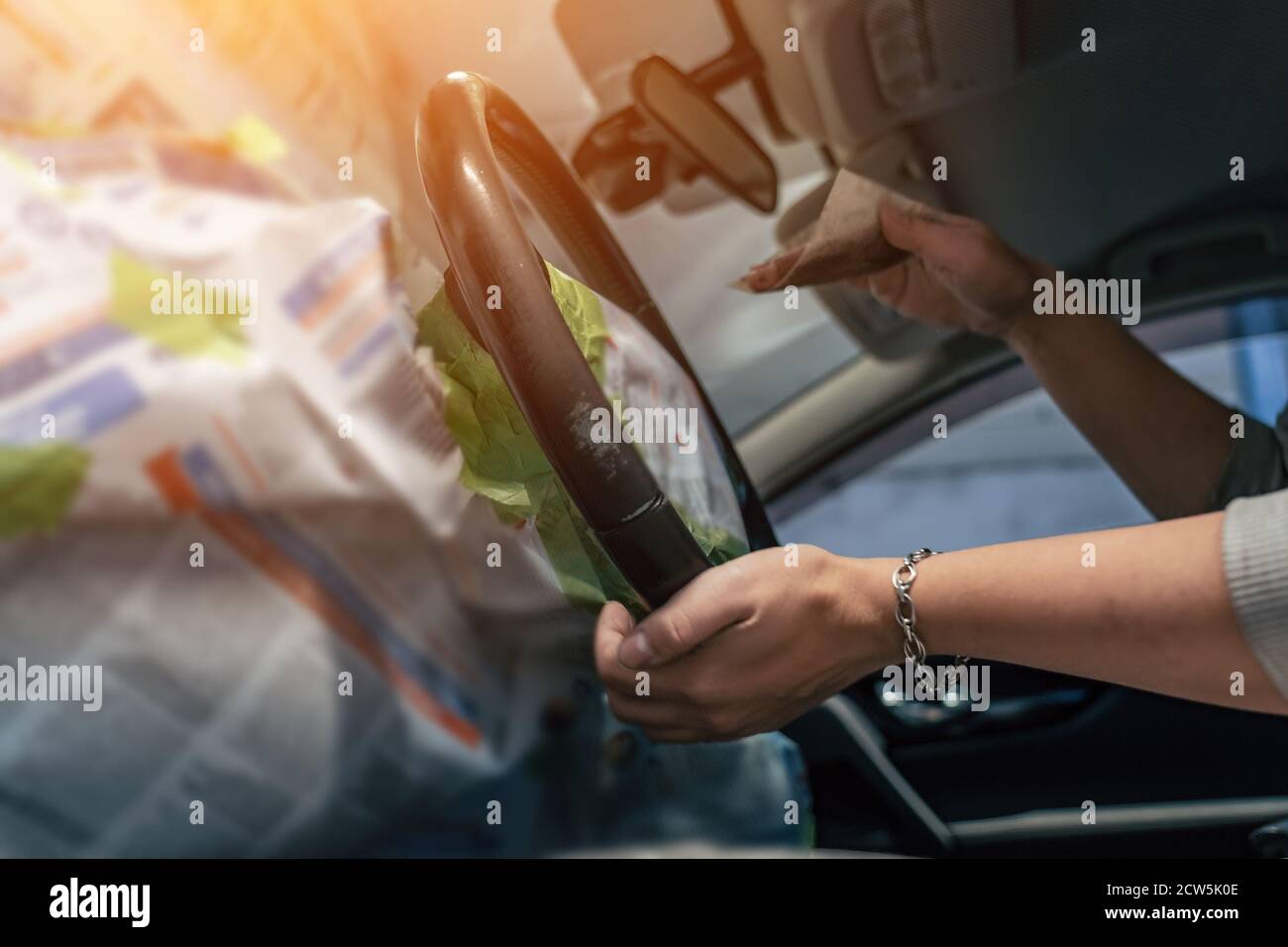 Service de détail, préparation du volant en cuir pour la peinture, les mains des femmes de travail essuient le volant avec du papier abrasif fin, la restauration et l'entretien de l'intérieur de voiture en cuir. Banque D'Images