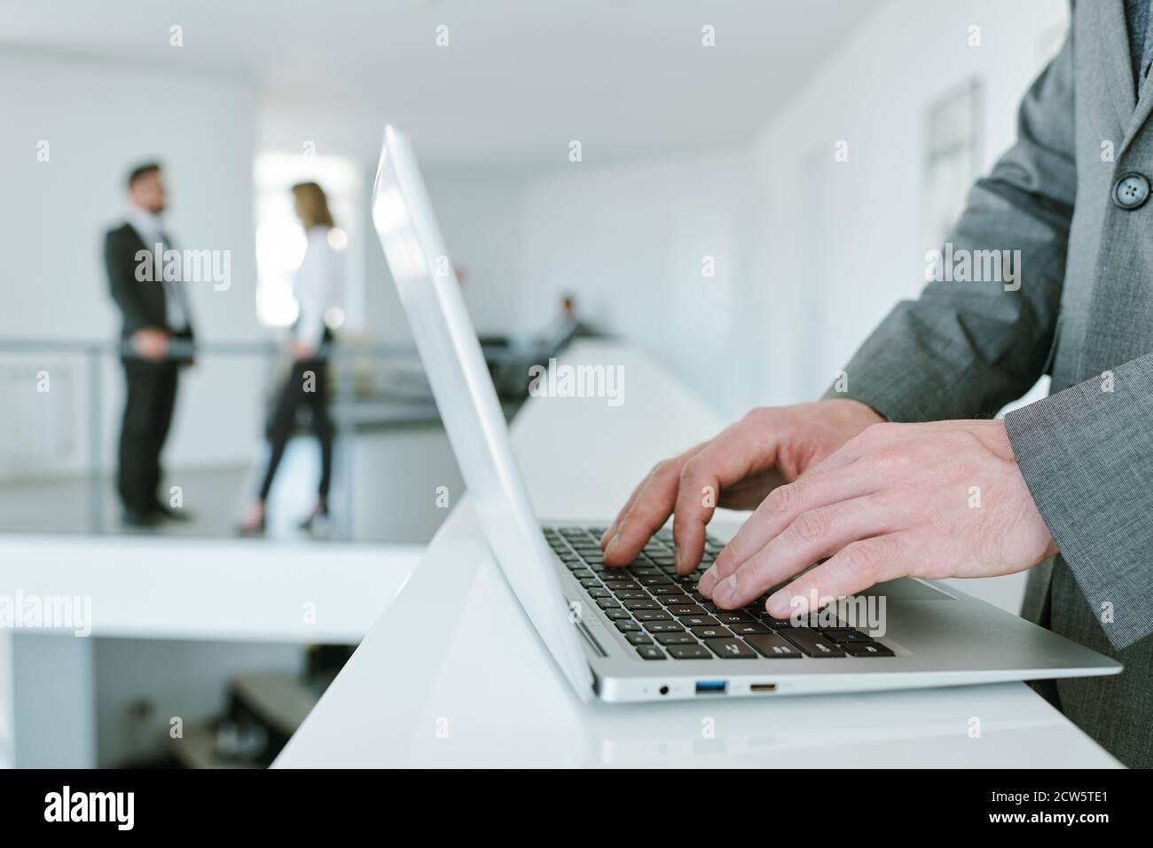 Mains de jeunes hommes d'affaires contemporains appuyant sur les boutons du clavier d'ordinateur portable Banque D'Images