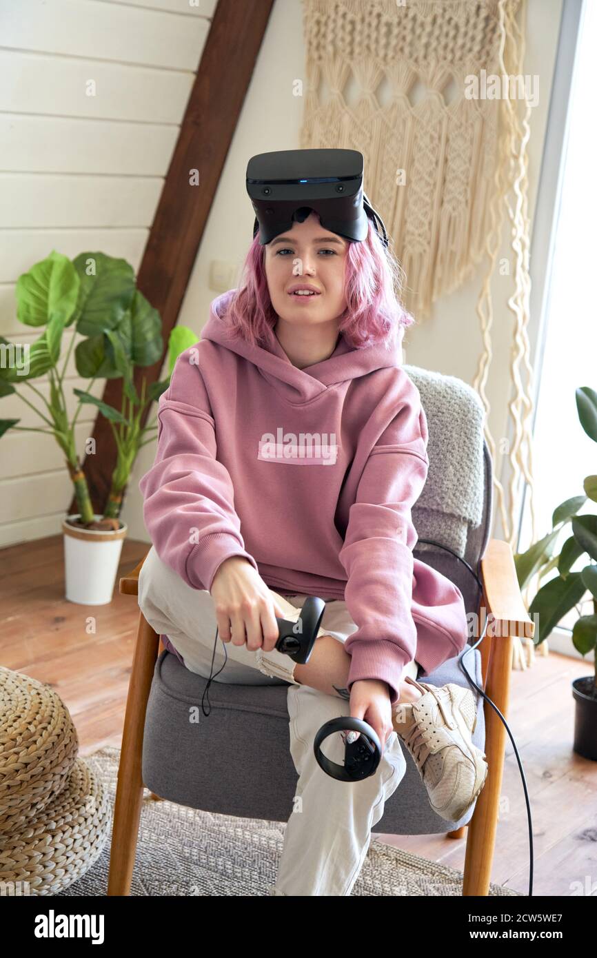 Mode femme porte des lunettes vr regarder la caméra s'asseoir dans la chaise, portrait vertical. Banque D'Images