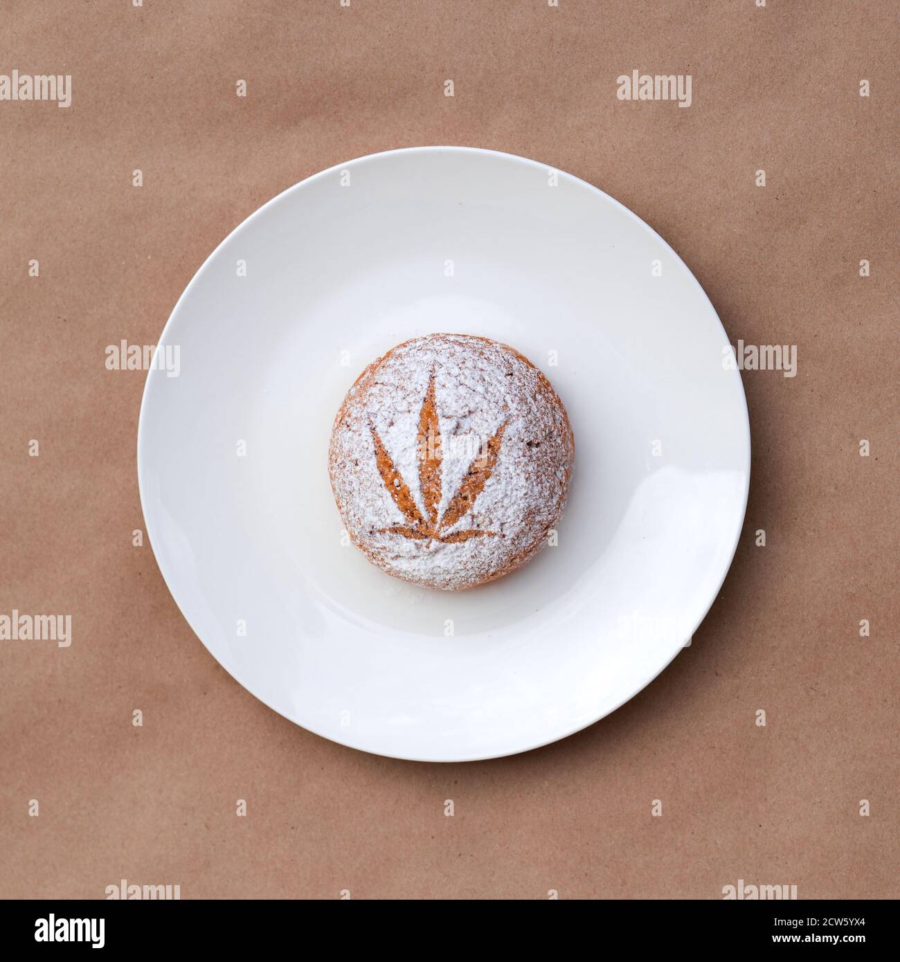 Modèle de feuille de cannabis faite avec du sucre en poudre sur les cookies sur fond kraft. Extraction de résine vivante de cannabis. Bannière Banque D'Images