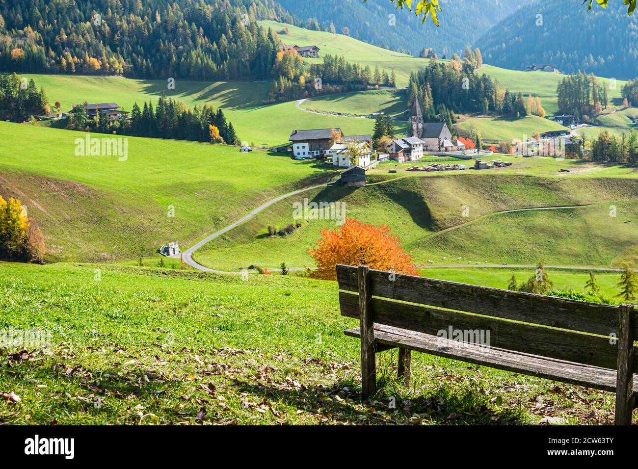 Le banc avec vue panoramique sur le village de Santa Magdalena dans le nord de l'Italie sur les pentes des Dolomites dans la vallée de Val di Funes. Banque D'Images