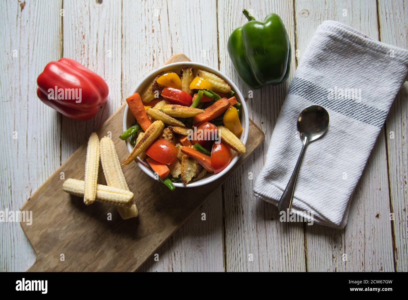 Légumes frits et ingrédients alimentaires crus sur un plat en bois en arrière-plan Banque D'Images