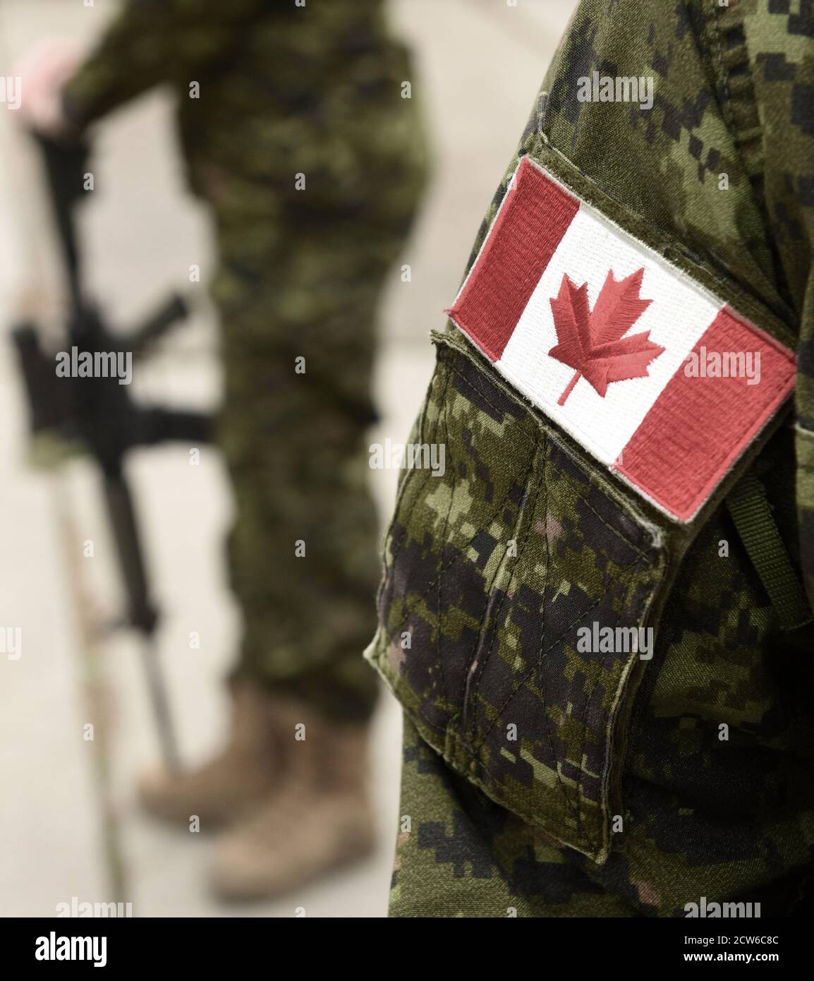 Drapeau du Canada sur l'uniforme militaire et guerrier avec arme sur l'arrière-plan. Les soldats canadiens. L'Armée canadienne. Le Jour du souvenir. La fête du Canada. Banque D'Images