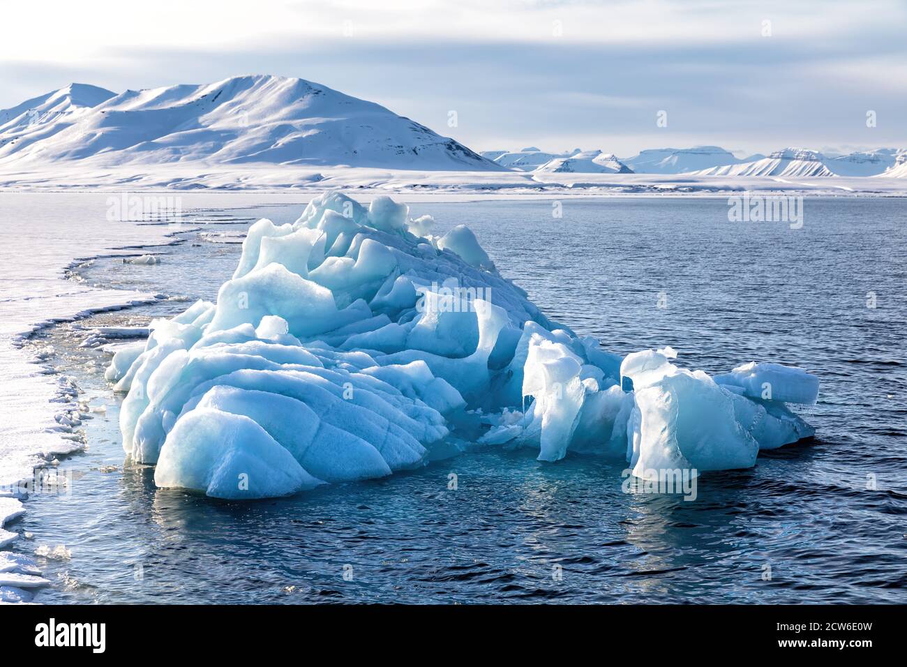 Iceberg bleu glacial au bord de la glace rapide, fjord Nordfjorden. Svalbard. Banque D'Images