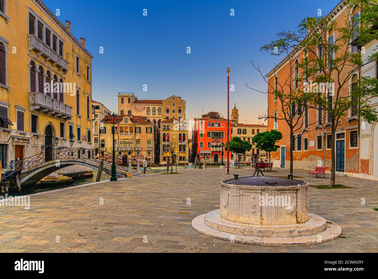 Campo San Vio avec palais Palazzo Cini et Palazzo Barbarigo, puits de pierre et pont sur le canal étroit d'eau, bâtiments sur la voie navigable du Grand Canal dans le centre historique de Venise en arrière-plan, Italie Banque D'Images