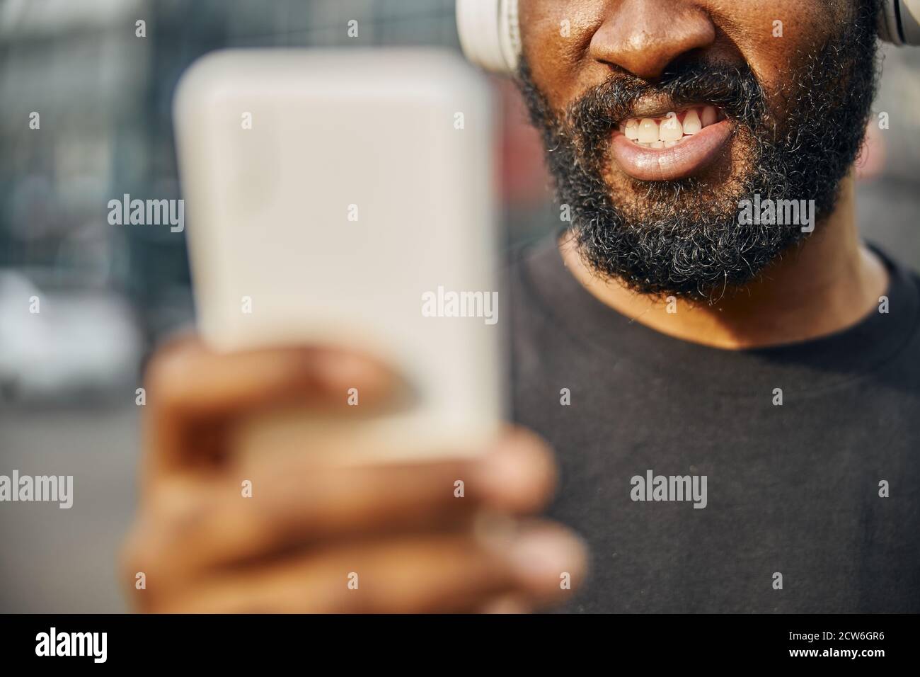Visage du jeune homme afro-américain barbu avec gadget Banque D'Images