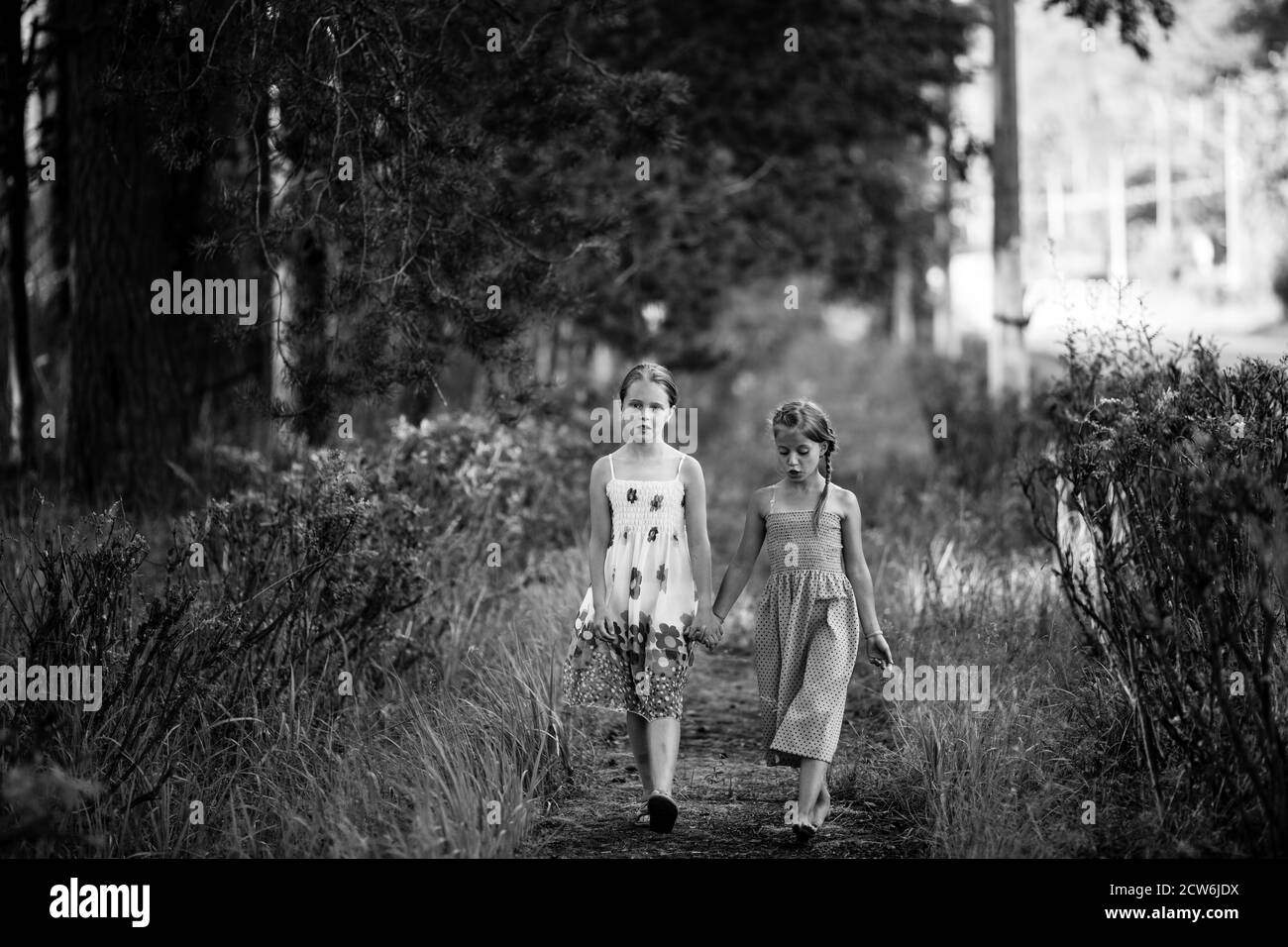Deux jeunes filles de dix ans marchent dans le parc. Photo en noir et blanc. Banque D'Images