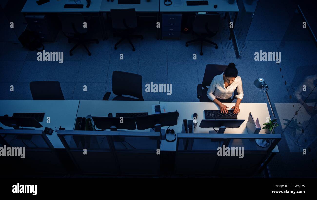 Seul travailler tard dans la nuit au bureau : femme d'affaires utilisant un ordinateur de bureau, analyser, utiliser des documents, résoudre des problèmes, terminer le projet. Élevée Banque D'Images