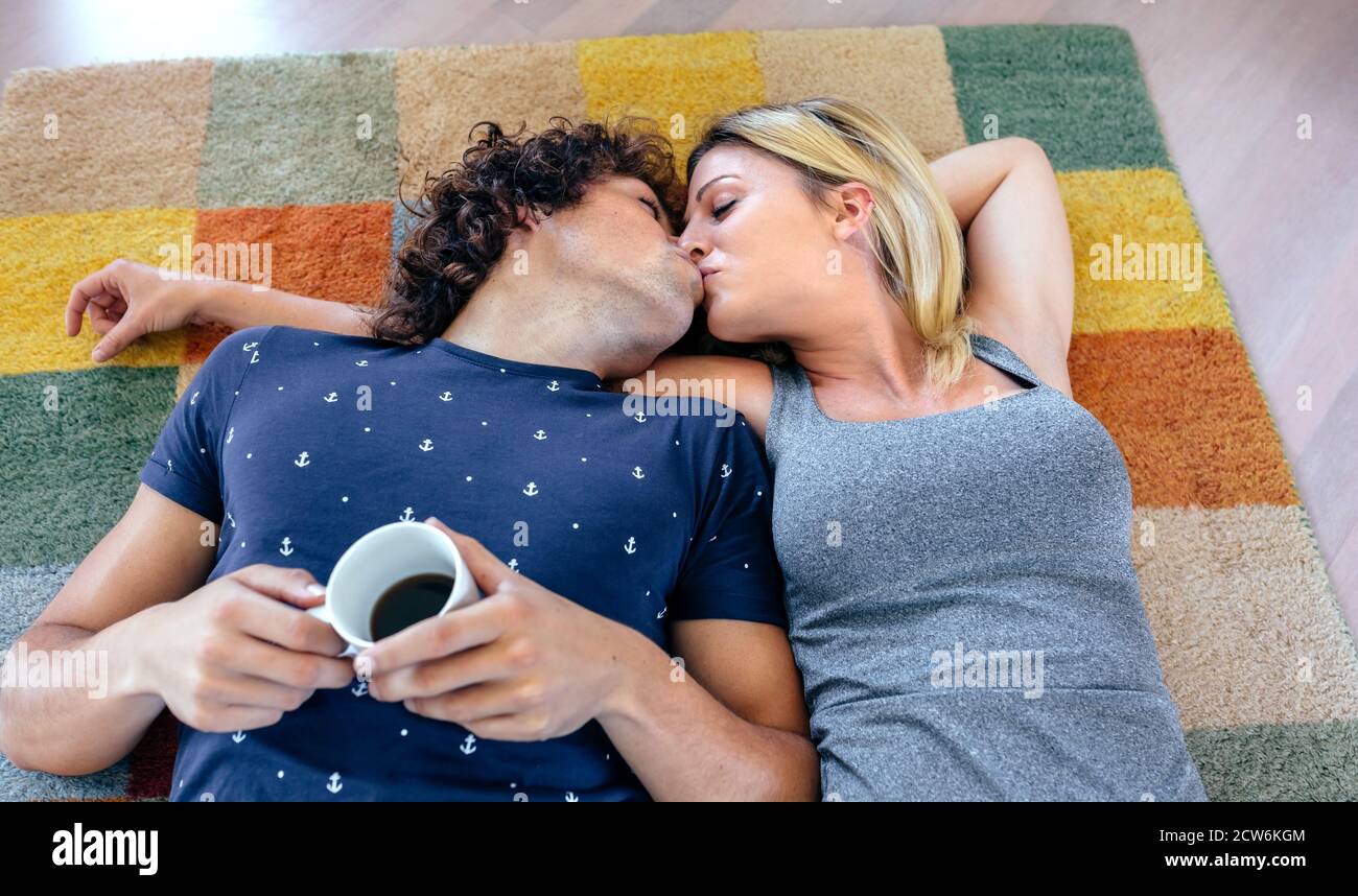 Couple embrassant couché sur la moquette Photo Stock - Alamy