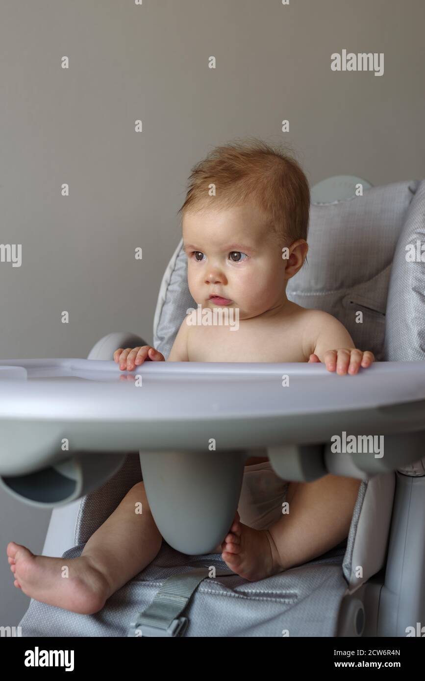 Elle pleure une petite fille assise sur sa chaise haute Banque D'Images