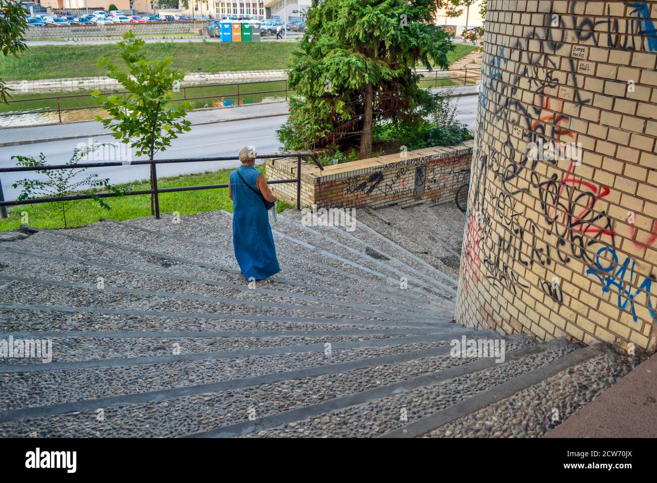 Zrenjanin, Serbie, 20 août 2016. Une femme vêtue d'une longue robe en denim qui descend dans les escaliers. Banque D'Images