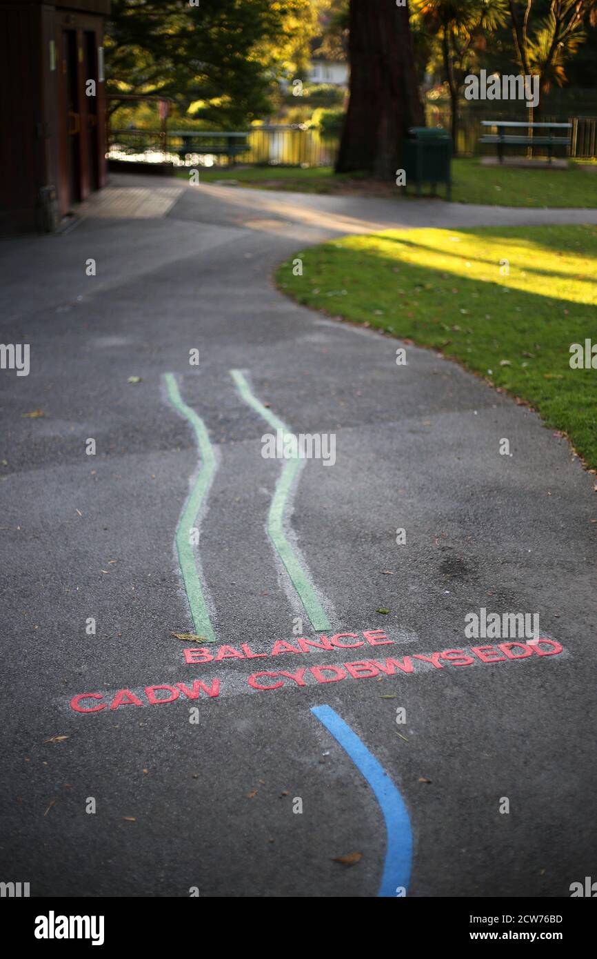 Jeu d'exercice pour enfants peint en anglais et gallois sur un chemin dans un parc Banque D'Images