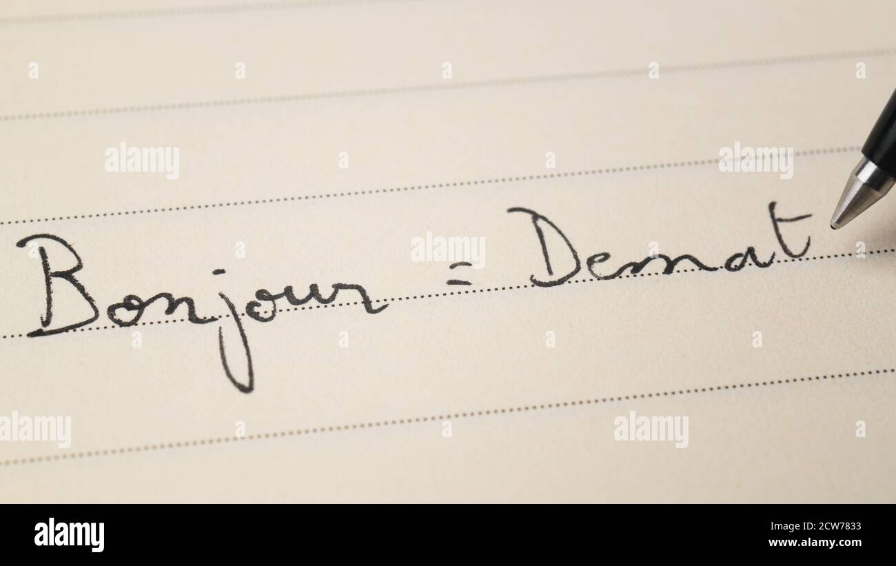 Débutant breton apprenant écriture Bonjour mot Bonjour en français Et Demat en breton pour faire ses devoirs sur une macro-ordinateur portable prise de vue Banque D'Images