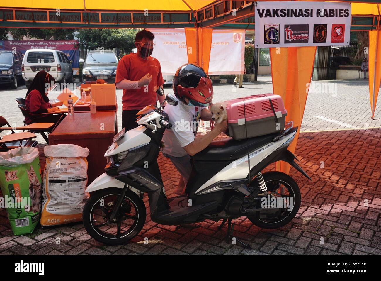 Jakarta, Indonésie. 28 septembre 2020. Un homme tient son chien avant que le chien de compagnie ne reçoive un vaccin gratuit contre la rage à Jakarta, en Indonésie, le 28 septembre 2020. La Journée mondiale de la rage est célébrée le 28 septembre afin de sensibiliser les animaux de compagnie à la prévention de la rage. Crédit: Arya Manggala/Xinhua/Alamy Live News Banque D'Images