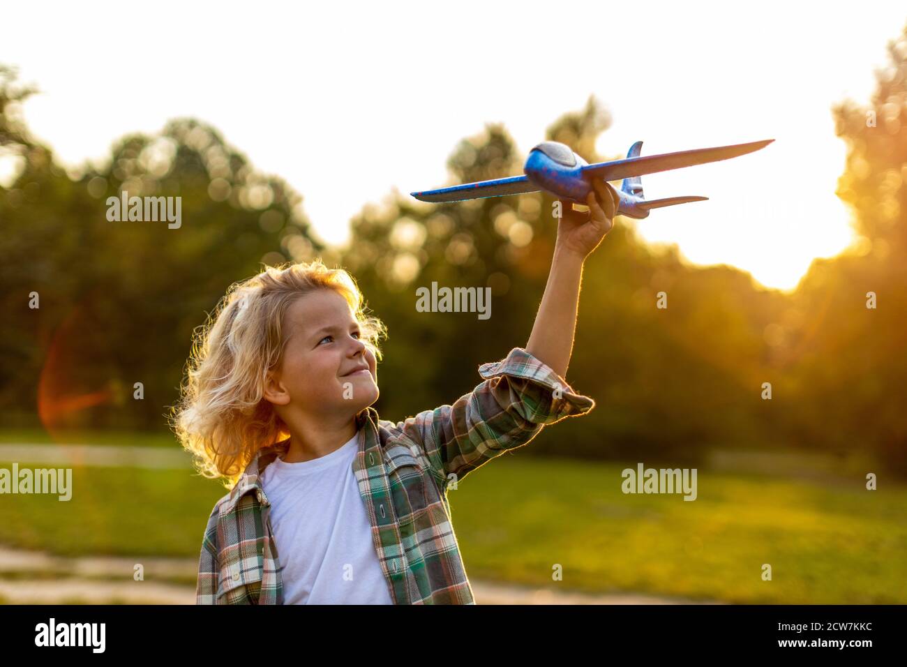 Petit garçon jouant avec l'avion jouet dans le parc Banque D'Images