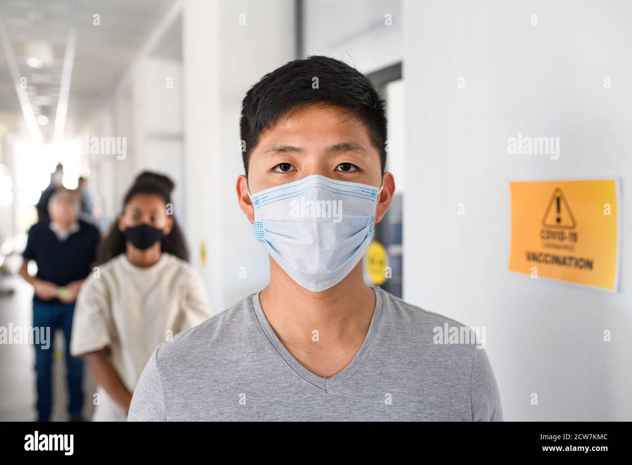Portrait des personnes avec des masques de visage en attente, coronavirus, covid-19 et concept de vaccination. Banque D'Images