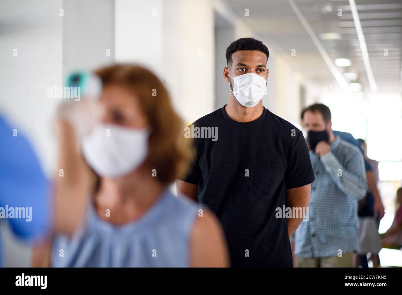 Portrait des personnes avec des masques de visage en attente, coronavirus, covid-19 et concept de vaccination. Banque D'Images