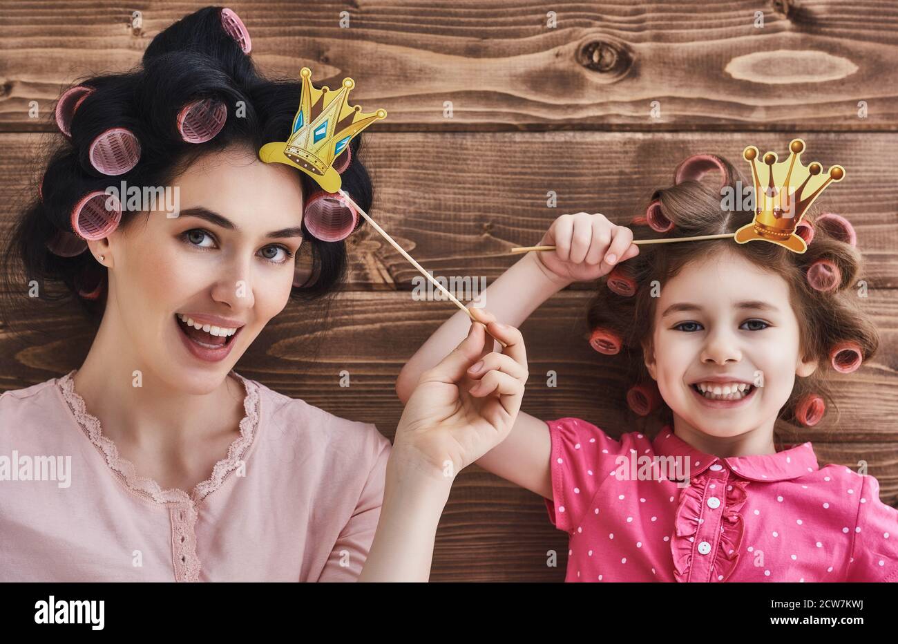 Famille drôle! Mère et son enfant fille fille avec un papier accessoires.  Beauté drôle enfant et maman tenant la couronne de papier sur le bâton  Photo Stock - Alamy