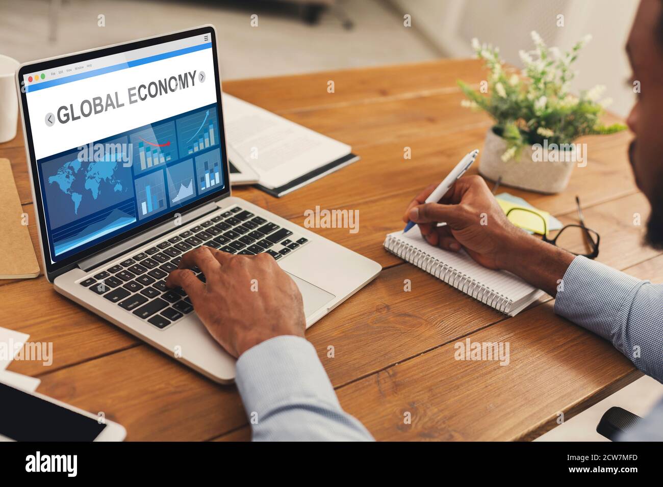 African Business Man at Laptop analyse des graphiques économiques au bureau Banque D'Images