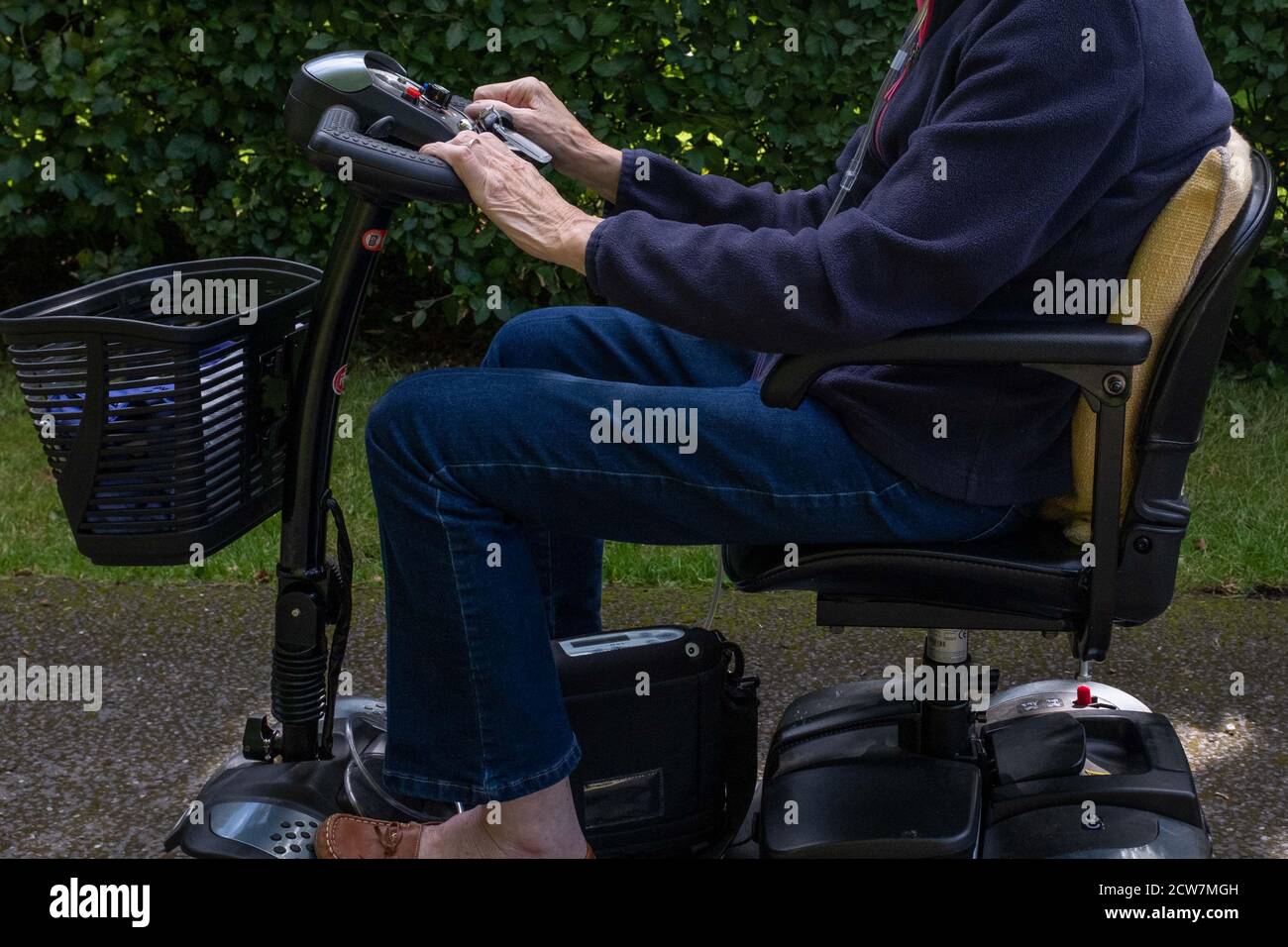 Une vieille dame dans un pull bleu et un Jean à cheval de mobilité, les épaules vers le bas coup seulement. Banque D'Images