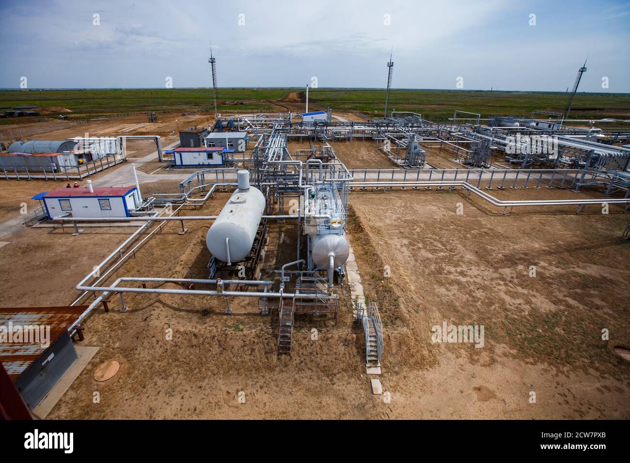 Raffinerie de pétrole dans les sables. Échangeurs thermiques, mâts légers et canalisations. Gisement de pétrole de Zhaik-Munai, Kazakhstan. Banque D'Images