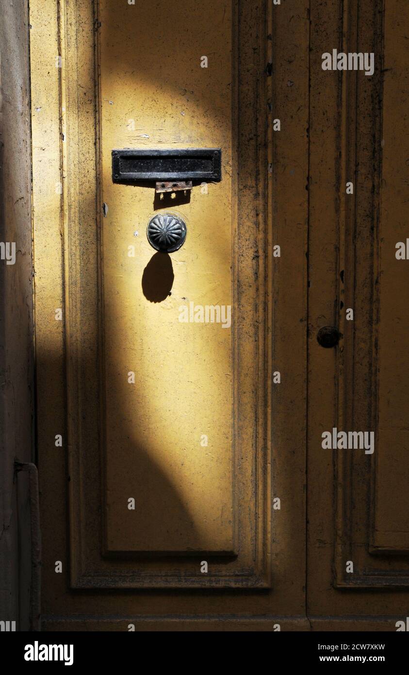 La lumière du soleil illumine un bouton de porte sur la porte jaune d'une résidence à la Valette, Malte. Banque D'Images