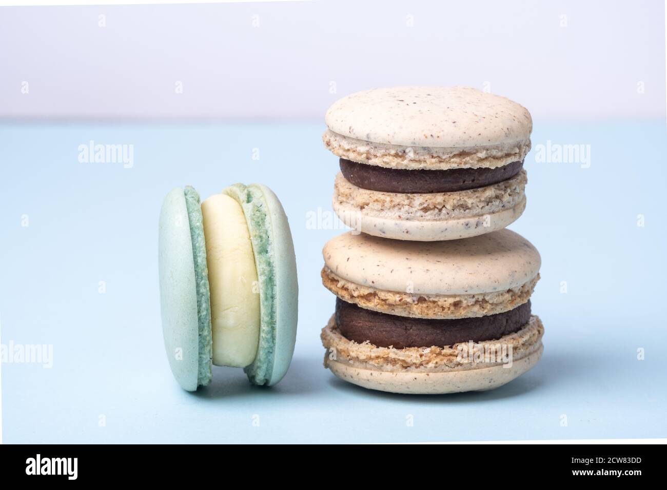Gros plan de délicieux macarons français. Différents types de macarons sur fond bleu - image Banque D'Images