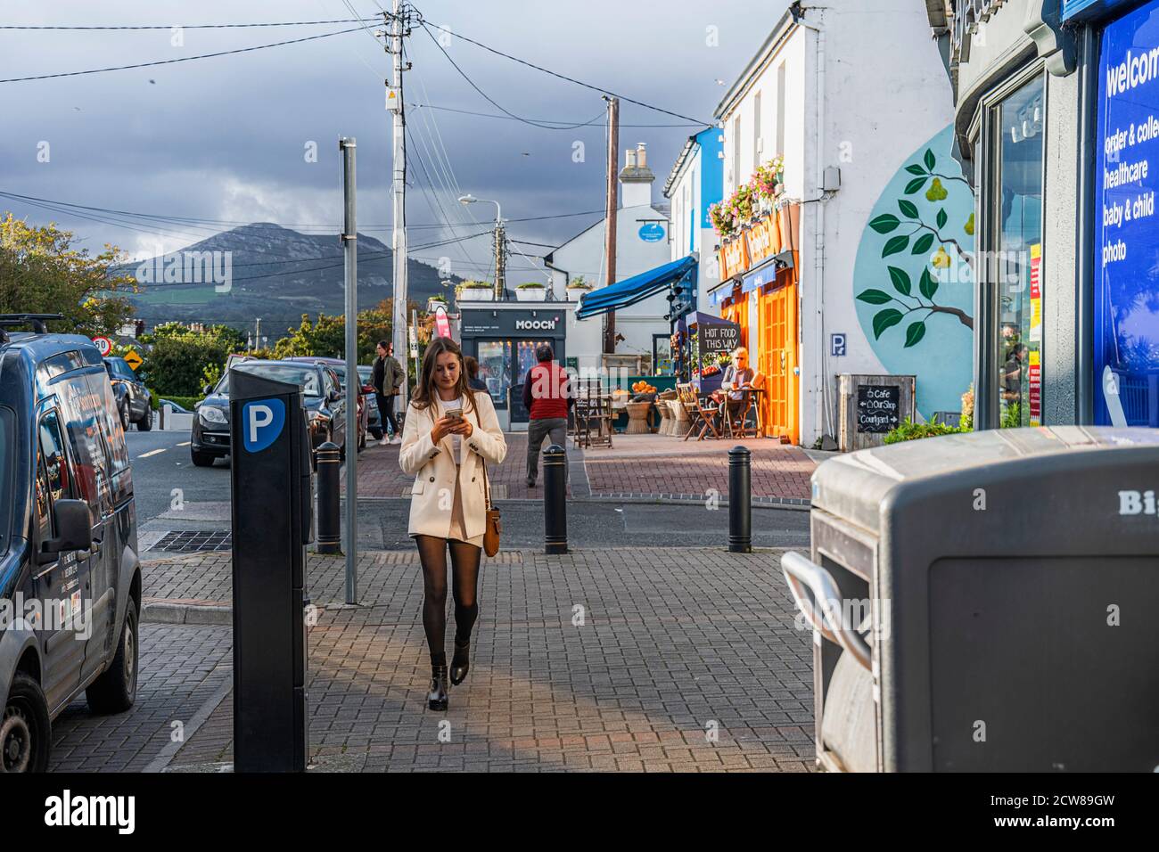 Vie quotidienne. La jeune fille tend la main vers la caméra avec son téléphone dans ses mains. Greystones. Irlande. Banque D'Images