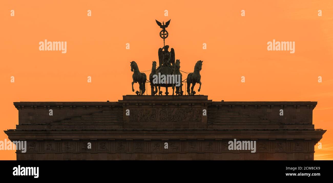 Coucher de soleil à la porte de Brandebourg (en allemand : Brandenburger Tor), un monument néoclassique du XVIIIe siècle à Berlin, en Allemagne. Une Quadriga se trouve en haut de la porte, Banque D'Images