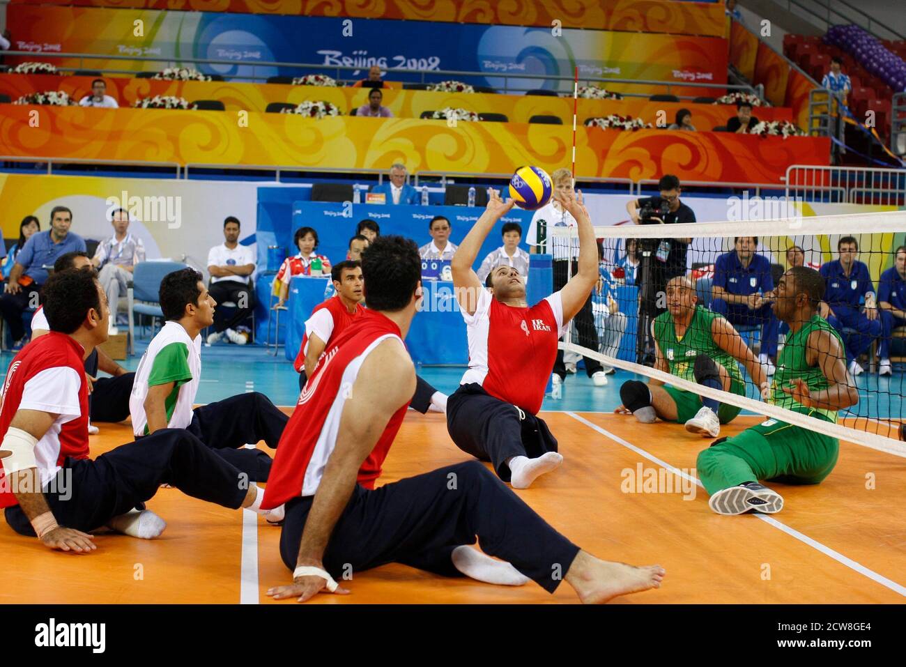 Beijing, Chine 8 septembre 2008: Le Brésil (vert) prend la République islamique d'Iran (rouge) dans l'action préliminaire de volleyball assis des hommes aux Jeux paralympiques de Beijing. L’Iran a facilement progressé avec une victoire à trois points. ©Bob Daemmrich Banque D'Images