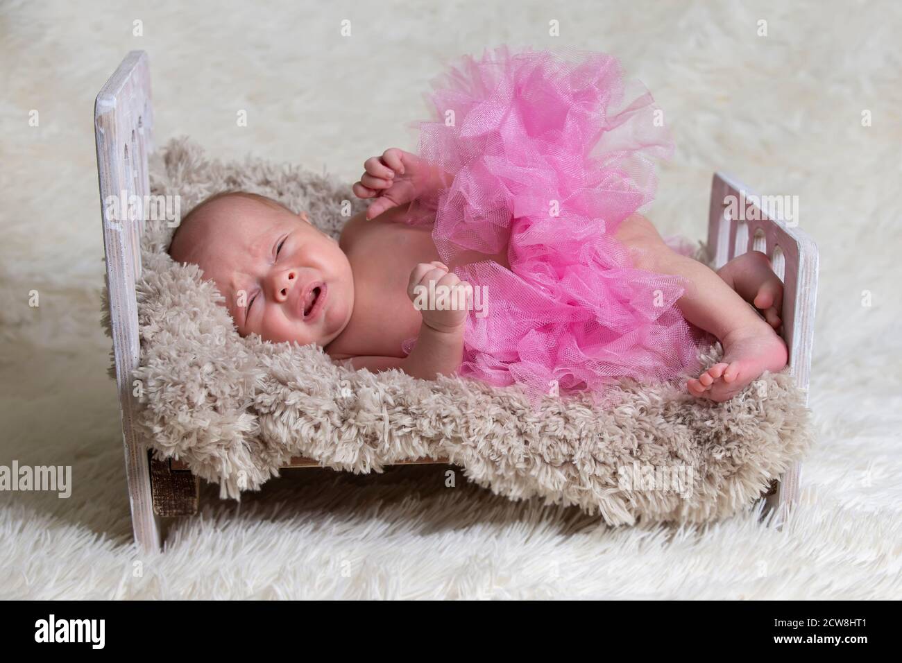 Nouveau Ne Bebe Pleure Dans Le Berceau Bebe Dans Une Jupe Rose Sur Un Lit De Fourrure Photo Stock Alamy