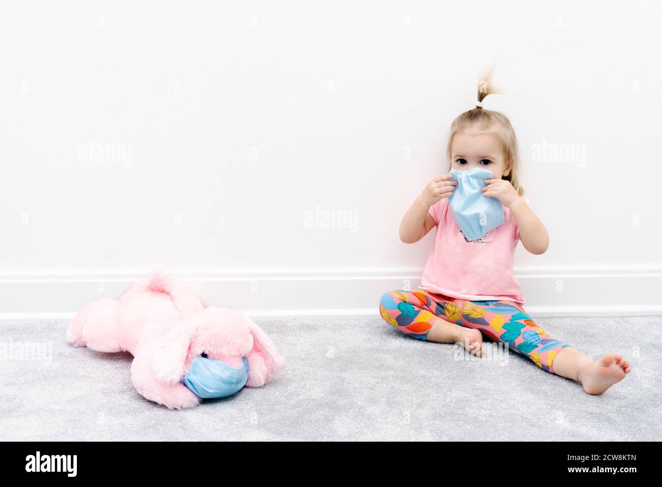 Petite Fille Caucasienne Bebe Dans Le Masque De Protection Du Visage Assis A Maison En Quarantaine Avec Jouet Chien Rose Photo Stock Alamy