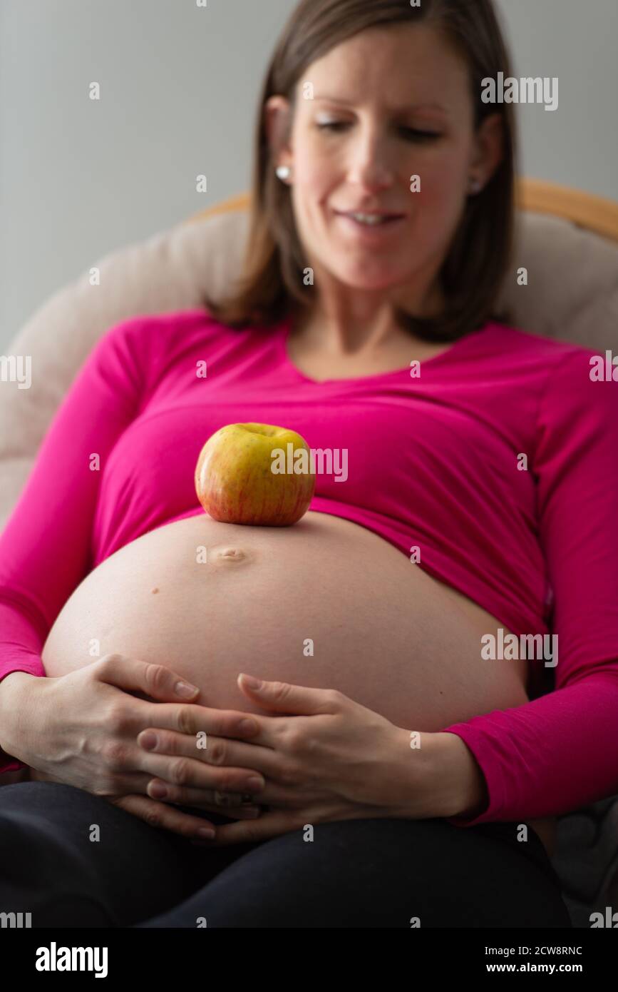 Pomme mûre saine sur le ventre gonflé d'une jeune femme enceinte ...