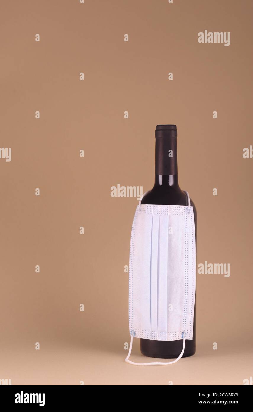Bouteille de vigne avec port de masque médical de protection concept créatif avec masque médical. Concept de protection des soins de santé avec espace pour le texte. VERTIC Banque D'Images
