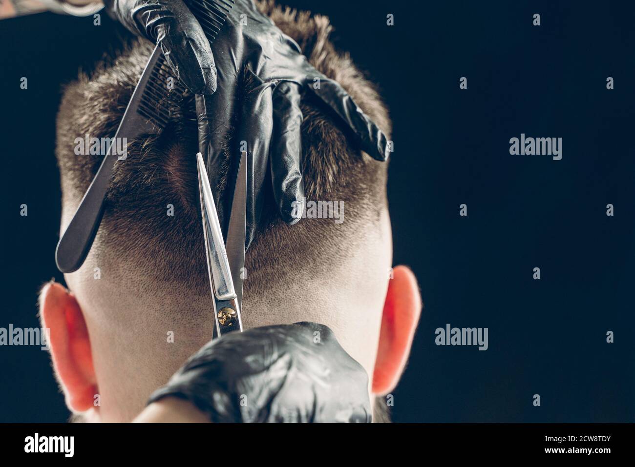 Coupe courte de cheveux de barbier du client avec des ciseaux Banque D'Images