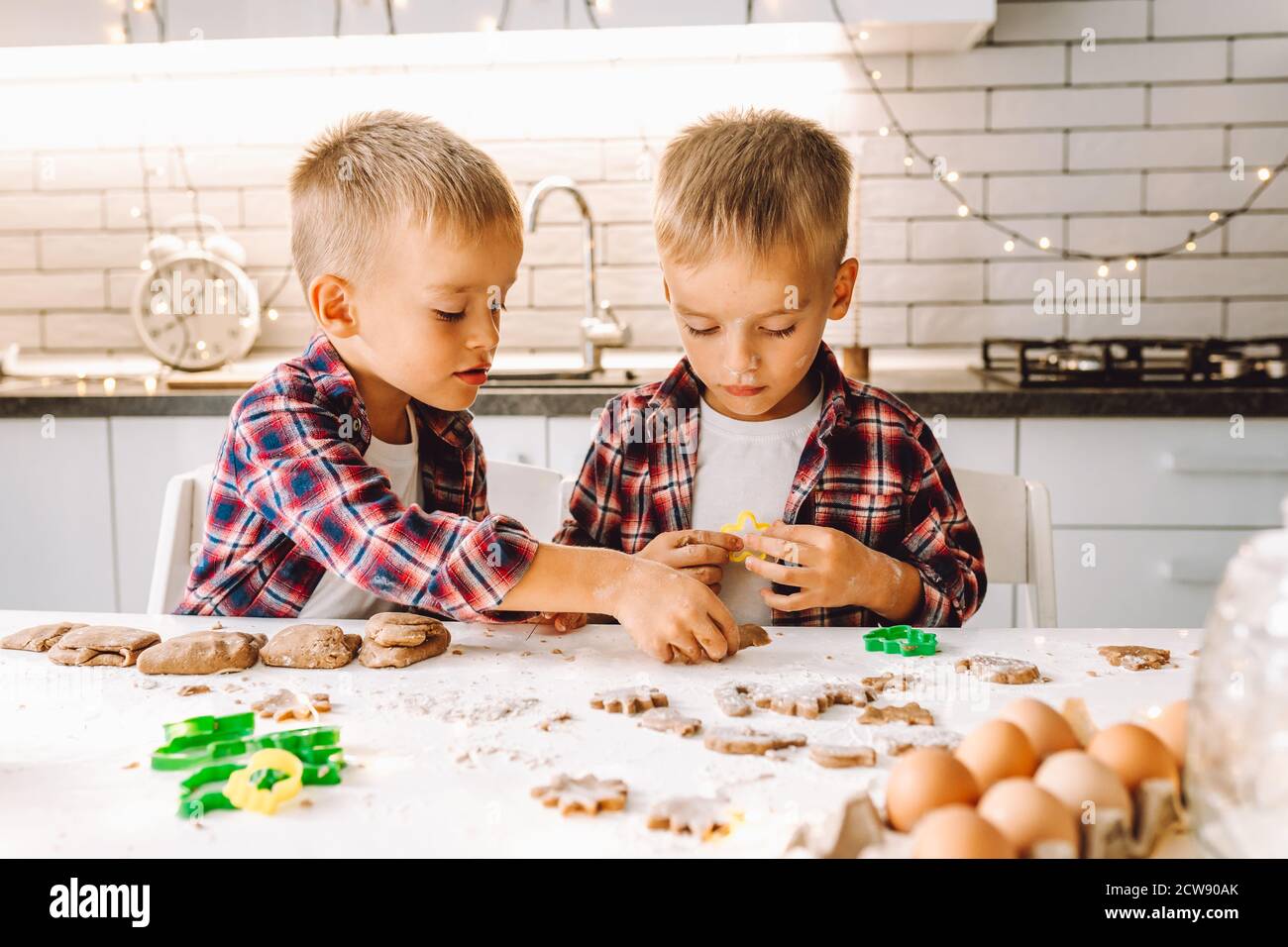 Deux garçons avec lits jumeaux préparent des biscuits pour Noël et nouvel an dans une cuisine légère. Banque D'Images